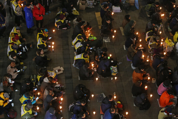 1월26일 밤 수원역 광장에서 열린 문화제에 촛불을 들고 앉은 참석자들.