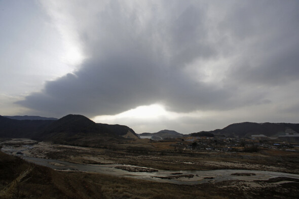 금강마을 뒤편으로 영주댐이 보인다. 마을을 물에 묻을 댐에서 시작된 구름이 마을과 내성천으로 시커멓게 번지고 있다.