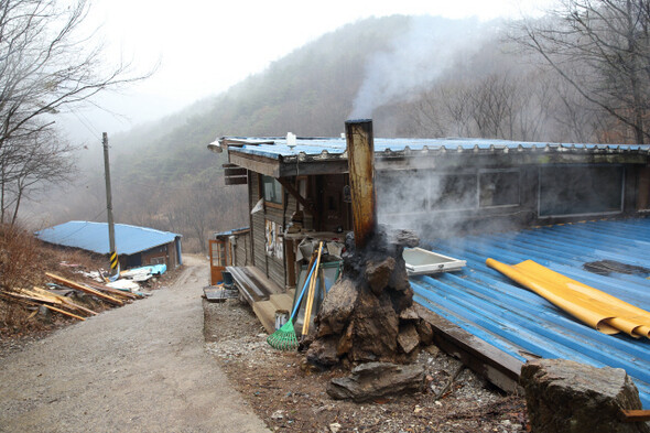 숲 속 헌책방. 장작을 때자 엉성하게 생긴 굴뚝으로 연기가 피어오른다.
