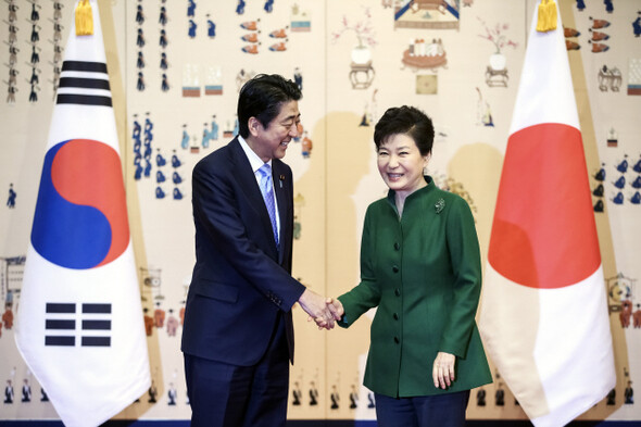 South Korean President Park Geun-hye and Japanese Prime Minister Shinzo Abe pose for a photo during their first summit since their inaugurations