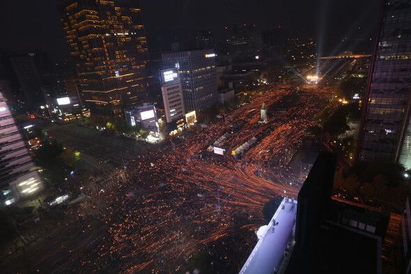 Participants in the second “Get Together! Get Angry! #Resign_ParkGeunhye Citizens’ Candlelight Assembly” march from Gwanghwamun Square toward Jongno