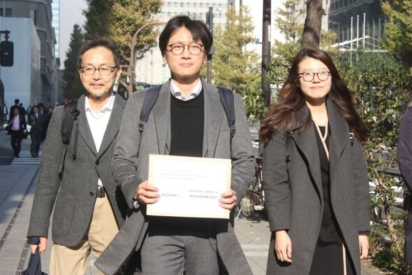 Attorneys representing Korean victims of forced labor under Japanese firms during the colonial occupation head the Nippon Steel and Sumitomo Metal headquarters in Tokyo on Dec. 4