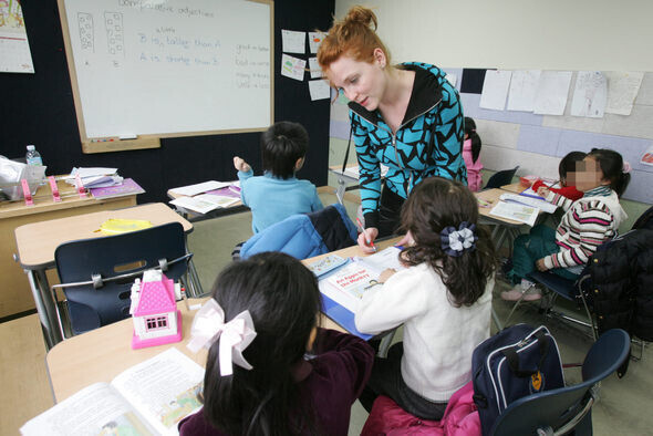 A native English teacher checks on their elementary-age Korean students in this undated file photo. (Hankyoreh file photo)