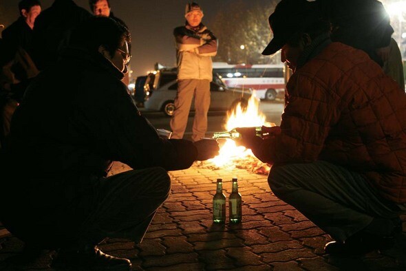 오전 5시27분, 일감이 들어오지 않을 것을 직감한 구직자들이 모닥불 주위에 둘러서서 소주를 나눠 마시고 있다. 