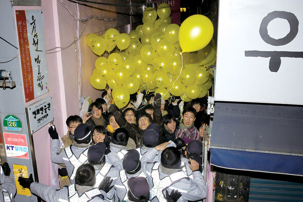 2008년 마지막 날 밤 서울 종로구 조계사 건너편 평화박물관으로 들어가는 골목길에서 몸싸움이 벌어지고 있다. 전교조 해직교사의 복귀를 바라는 풍선을 들고 나오는 시위 참여자들을 경찰이 막아섰다. 경찰이 보기에 불법 시위용품이면, 현존하는 명백한 위협이 없어도 시위 장소에 나오지 못한다.