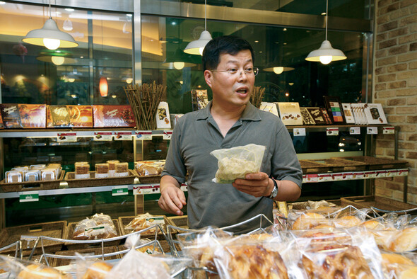 부천의 한 빵가게에서 전 삼성 법무팀장 김용철 변호사가 손님에게 빵에 대해 설명하고 있다.