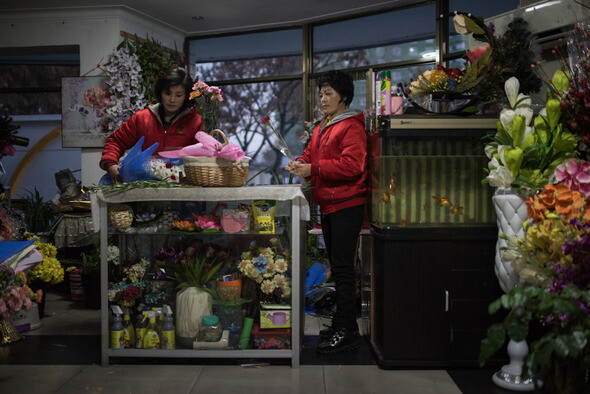 A woman prepares a bouquet to sell at a flower shop in Pyongyang. (AFP/Yonhap News)