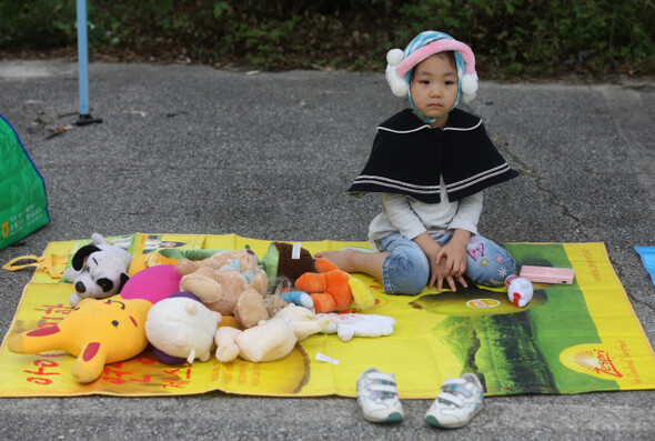 자신이 가지고 놀던 인형을 펼쳐놓은 어린이가 손님을 기다리고 있다. 한겨레 윤운식 기자