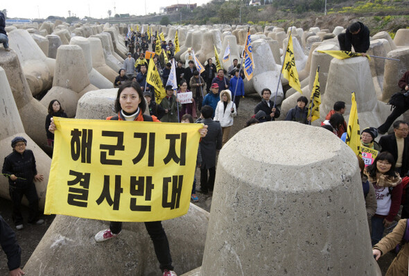 해군기지 건설에 반대하는 주민과 활동가들이 경찰 저지선을 뚫고 공사 현장 인근으로 접근해 현수막을 펼쳐들고 있다.