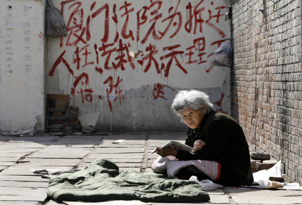 ‘여기, 사람이 살고 있다.’ 법원의 철거 강제집행 결정에 항의하는 한 주민이 베이징 외곽 샤먼 지역에서 홀로 연좌시위를 하고 있다. REUTERS/ CLARO CORTES IV