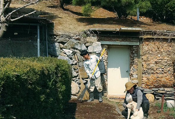 산기슭 축대를 벽면 삼아 지은 석굴. 봄날 그 앞에서 밭을 만들고 있다.강명구 제공