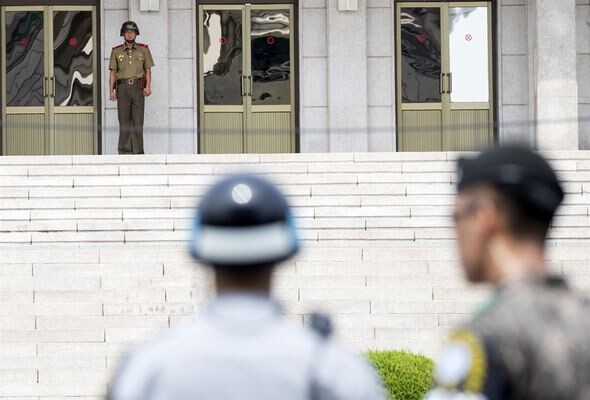 A North Korean soldier looks across the DMZ to Panmunjeom Peace Village on July 19 in Paju