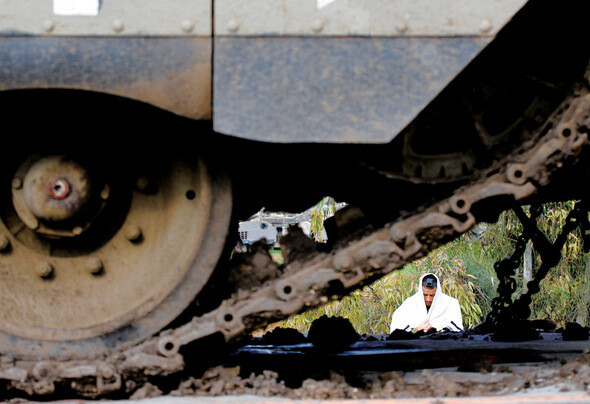 가지지구 외곽에 전진 배치된 이스라엘 병사가 기도를 하고 있는 모습이 장갑차의 무한궤도 사이로 눈에 띈다. REUTERS/ YANNIS BEHRAKIS