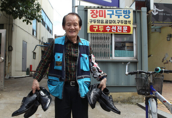 &raquo; 지난 6월29일 전북 전주 경원동 ‘장미구두방’ 앞에서 주인 최수범씨가 손님들이 맡겨놓은 구두를 들고 밝게 웃고 있다. 한겨레21 이종찬  