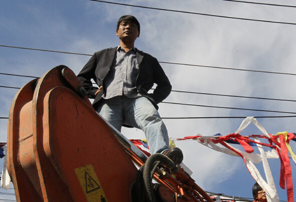 송경동 시인은 최근 2~3년 새 젊은 작가들의 '순회 투쟁'을 주도하는 인물 가운데 하나다. 송 시인이 2010년 10월 서울 금천구 기륭전자 옛 공장 앞에서 굴착기 위에 올라 용역들의 진입을 저지하고 있다. 한겨레 김태형