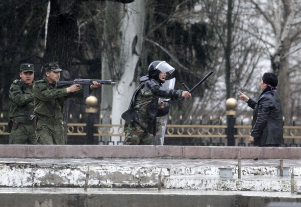 키르기스스탄 경찰들이 4월7일(현지시각) 수도 비슈케크 정부청사 주위에서 시위대를 총과 곤봉으로 위협하고 있다. 경찰은 이날 시위대에 발포해 수백 명의 사상자가 발생했다. 연합 AP