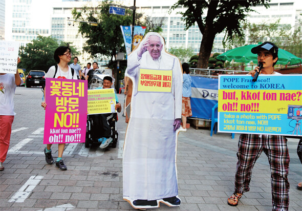 ‘장애등급제 부양의무제 폐지 공동행동’ 회원들이 지난 7월11일 서울 명동성당 앞 거리에서 프란치스코 교황의 꽃동네 방문에 반대하는 퍼포먼스를 벌였다. 비마이너 제공