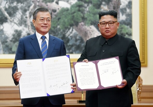 South Korean President Moon Jae-in and North Korean leader Kim Jong-un hold up their respective copies of the Pyongyang Declaration after signing the agreement at the Paekhwawon Guest House in Pyongyang on Sept. 19. (photo pool)