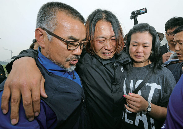 경기도 평택 쌍용자동차 공장 인근 송전탑에서 농성을 벌여온 금속노조 쌍용차지부 복기성 비정규직 수석부지회장(가운데)이 171일 만에 송전탑을 내려와 아내(오른쪽)와 만난 뒤 눈물을 쏟고 있다.