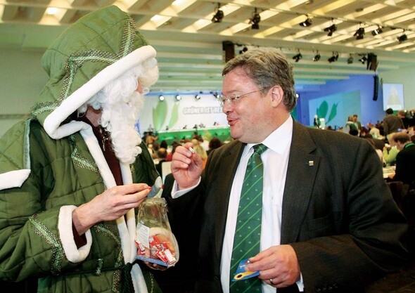 라인하르트 뷔티코퍼 독일 녹색당 공동대표가 2006년 12월 콜롬에서 열린 한 파티에서 산타클로스 복장의 남자로부터 공정무역 초콜릿을 건네받고 있다. REUTERS/ ARND WIEGMANN

