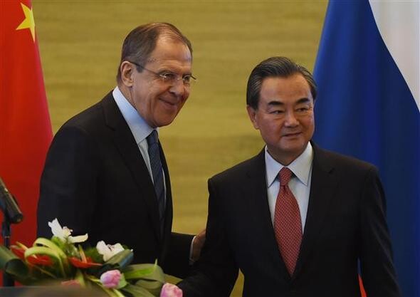 Russian Foreign Sergey Lavrov and Chinese Foreign Minister Wang Yi shake hands at a press conference after their meeting at the ministry in Beijing