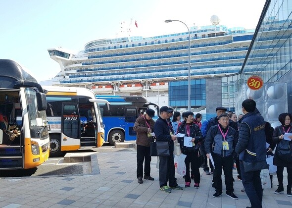 Chinese tourists board their cruise ship in Jeju Island after shopping on Mar. 15