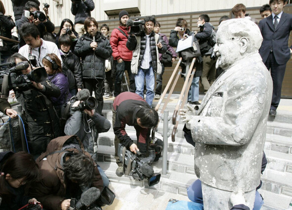 지난 5월11일 일본 오사카 도톤보리강에서 발견된 켄터키프라이드치킨 마스코트 할랜드 데이비드 샌더스 동상과 이를 취재 중인 보도진. 1985년 한신 타이거스가 센트럴리그에서 21년 만에 처음 우승할 당시 열광한 팬들이 한신의 강타자 랜디 배스와 닮은 이 동상을 들고 환호하다 도톤보리강에 빠뜨렸다. 그 이후 한신 타이거스는 24년간 우승을 하지 못했다. 사진 REUTERS
