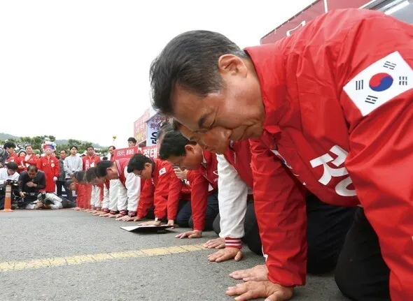 Members of the ruling Saenuri Party bow in front of voters