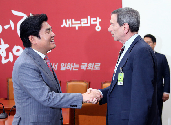 Saenuri Party floor leader Won Yoo-cheol shakes hands with former US State Department Special Advisor for Nonproliferation and Arms Control Robert Einhorn at the National Assembly in Seoul