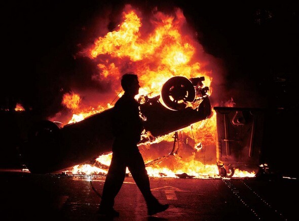 ‘그리스는 전쟁 중?’ 한 소년의 죽음이 촉발한 그리스 시민들의 분노가 그리스 전역의 거리를 휩쓸고 있다. 지난 12월8일 격렬한 시위가 벌어진 아테네 중심가에서 한 시민이 뒤집힌 채 화염에 휩싸인 차량 곁을 지나치고 있다. REUTERS/ YIORGOS KARAHALIS