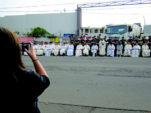 지난 9월29일 제주 강정 해군기지 공사현장 정문에서 생명평화 미사를 봉헌하고 있는 신부와 수녀의 모습을 사진으로 담고 있는 이아름씨. 