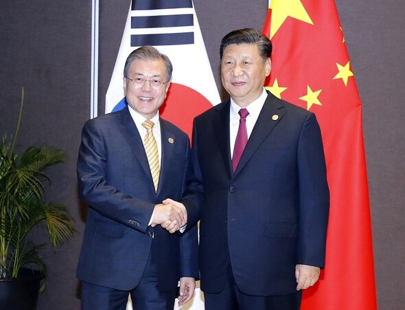 South Korean President Moon Jae-in and Chinese President Xi Jinping shake hands after their bilateral summit in Port Moresby