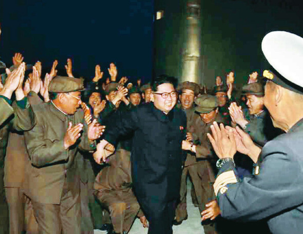 North Korean leader Kim Jong-un is cheered after observing the launch of a ballistic missile from a submarine in the East Sea