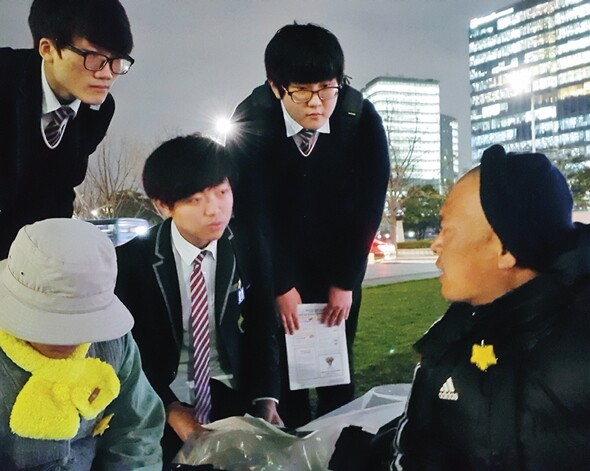 4월7일 저녁 7시를 넘긴 시간, 경기도 용인에 있는 고등학교를 다닌다는 학생 3명이 정부서울청사 건물 맞은편에 있는 돗자리 농성장을 찾아왔다. 민우 아빠가 학생들과 대화를 나누고 있다. 김효실 기자