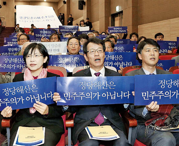  party leader Lee Jeong-hee (far left) and other party members hold placards opposing the possible disbandment