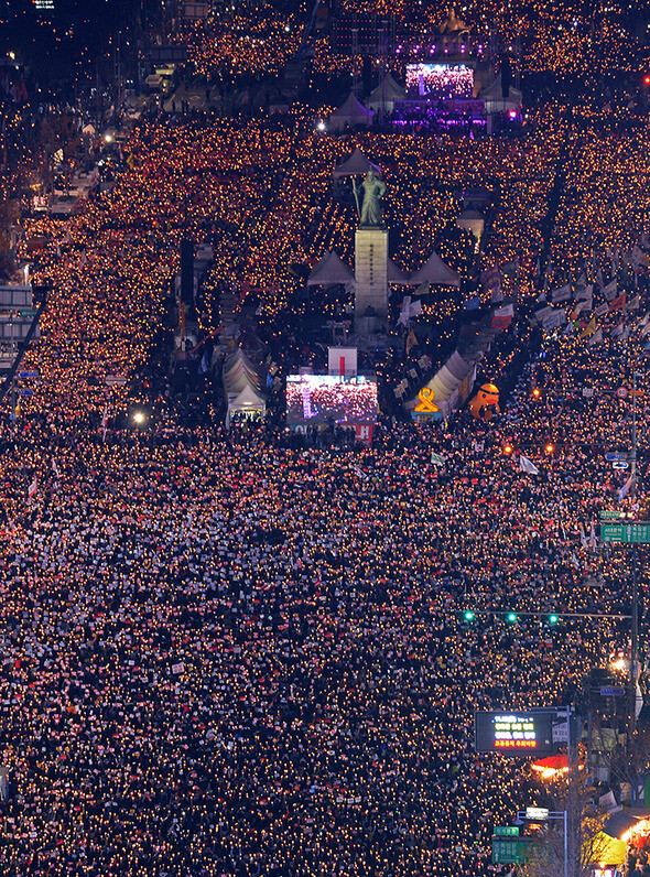 Participants hold candles at the fourth public demonstration calling for an investigation into the Choi Sun-sil scandal and President Park Geun-hye’s resignation