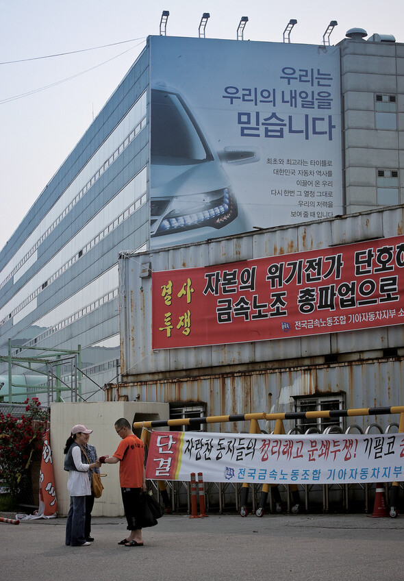 한 노조원이 정문 앞에서 가족에게 옷가지와 음식 등이 담긴 봉지를 받고 있다.