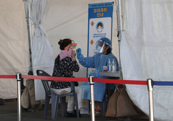 A person gets tested for COVID-19 at a walk-in screening center near Seoul’s Garak Market. (Yonhap News)