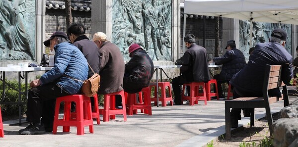 People eat lunch from a soup kitchen set up in Seoul’s Tapgol Park in Jongno District on April 6. (Kim Hye-yun/The Hankyoreh)