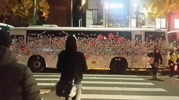 Participants on the fourth national candlelight demonstration in central Seoul affix flower stickers to decorate a police bus barricade near Gyeongbok Palace