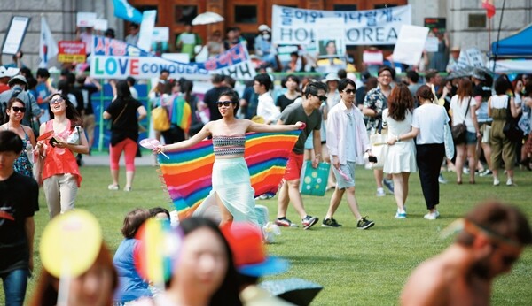 제16회 퀴어문화축제가 열린 2015년 6월28일 이전과 이후, 한국 성소수자 인권의 역사는 달라졌다. 이날 서울광장에서 퀴어문화축제를 즐기는 사람들 뒤로 보수 개신교의 펼침막이 보인다. 연합뉴스