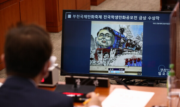 Park Bo-gyoon, South Korea’s culture minister, answers questions from lawmakers during a parliamentary audit on Oct. 5 while looking at a comic that had been awarded a top prize at BICOF. (pool photo)