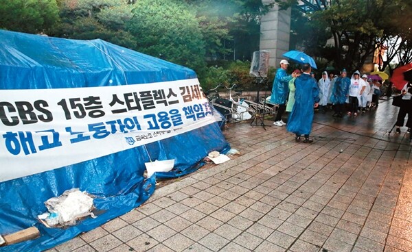 차광호 스타케미칼 해고자복직투쟁위원회 대표가 굴뚝에 오른 지 400일째 되는 날(6월30일), 해고자들이 모기업 스타플렉스 사옥(서울 목동) 앞에서 비를 맞으며 고용승계를 촉구하고 있다. 류우종 기자