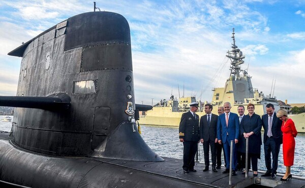 French President Emmanuel Macron (second from left) and former Australian Prime Minister Malcolm Turnbull (center) stand on the deck of the HMAS Waller, a Collins-class submarine operated by the Royal Australian Navy, in Sydney, May 2018. (AP/Yonhap News)
