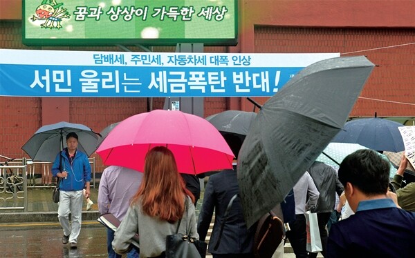 서울 광진구 구의동 지하철 2호선 강변역 앞을 출근하는 시민들이 지나고 있다. 건널목 앞에는 ‘세금폭탄’에 반대하는 펼침막이 걸려 있다. 한겨레 강재훈 기자
