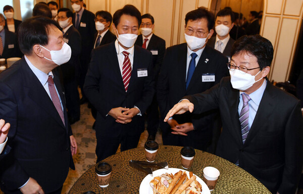 Former Prosecutor General Yoon Seok-youl (far left) and former lawmaker Yoo Seong-min (far right), both candidates in the People Power Party's presidential primary, look elsewhere after greeting each other at the “2021 People Hope Forum” held Thursday in Seoul’s Yeouido. (National Assembly pool photo)