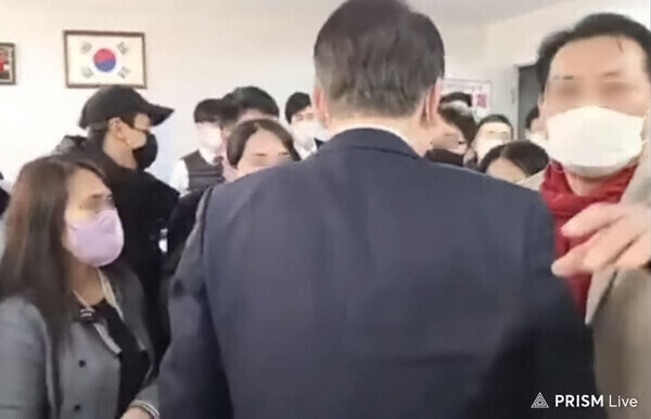 A shaman surnamed Jeon (far right) guides Yoon Suk-yeol (center, back turned) during his visit to the party’s network headquarters on Jan. 1. (still from YouTube video)
