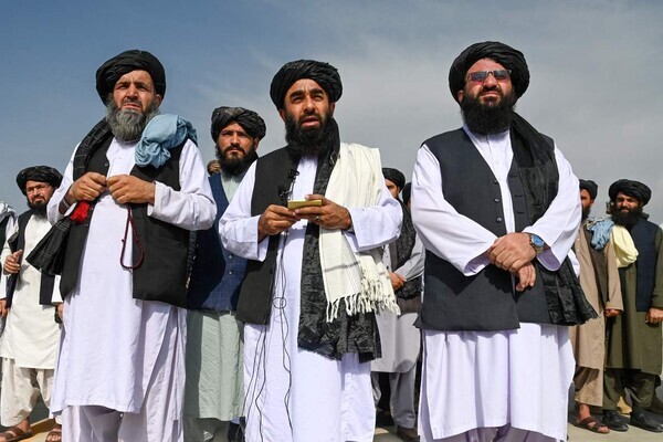 Taliban spokesperson Zabihullah Mujahid (center) speaks to the media at the airport in Kabul, Afghanistan, on Tuesday. (AFP/Yonhap News)