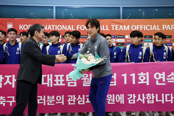 홍명보 남자 축구대표팀 감독이 6일 인천국제공항을 통해 귀국해 정몽규 대한축구협회장으로부터 꽃다발을 받고 있다. 연합뉴스
