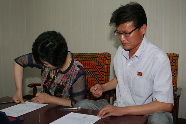 The family of one of 12 North Korean waitresses stamping a letter granting power of attorney to MINBYUN